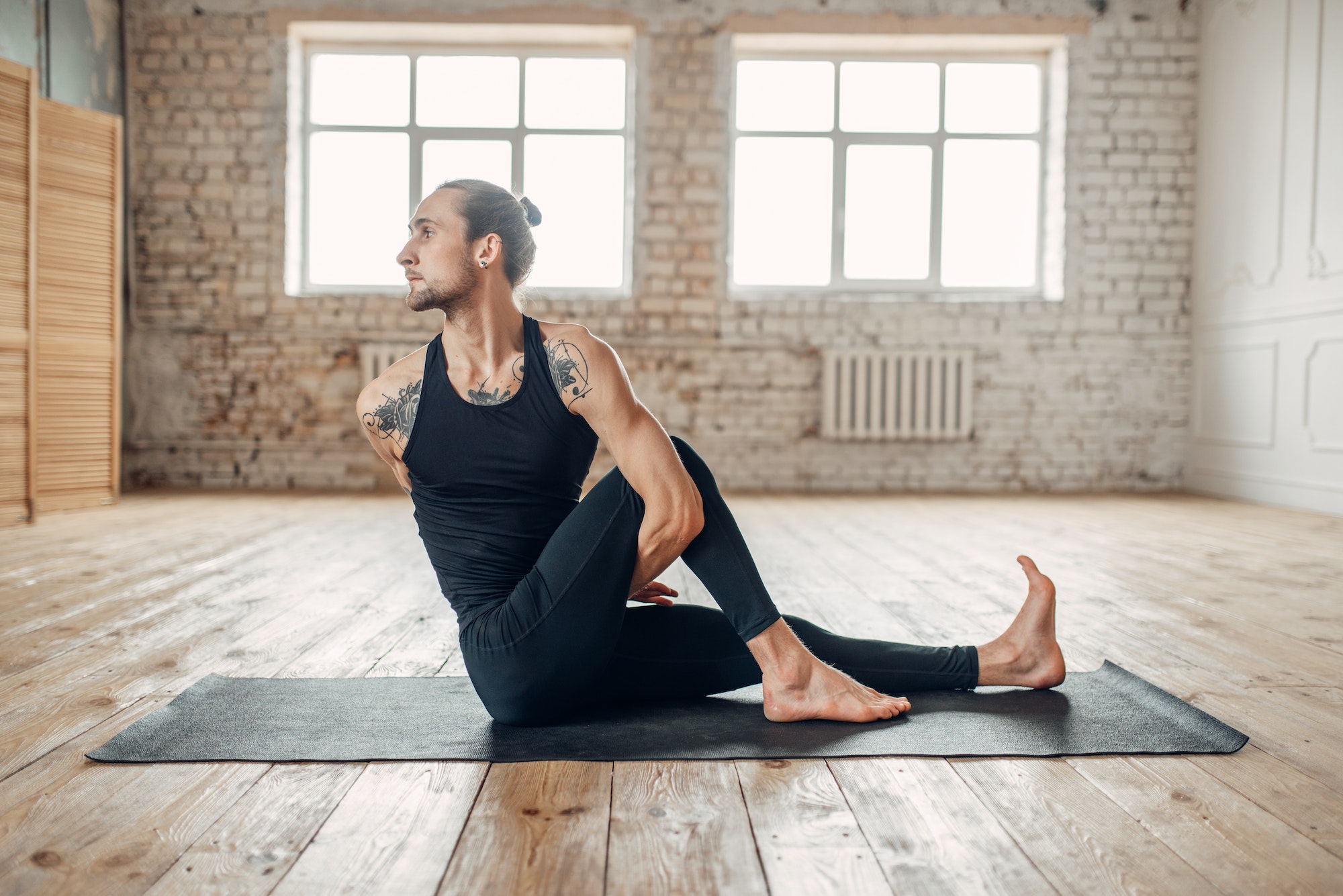 Male yoga in gym, balance exercise on mat